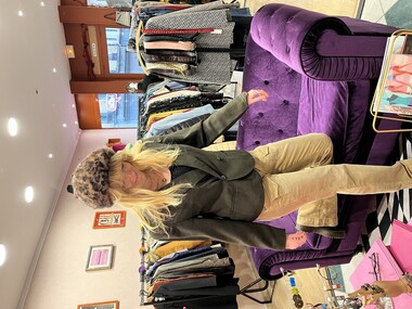 Oksana, gérante de Rembobine, dans sa boutique avec un bonnet brun et une veste