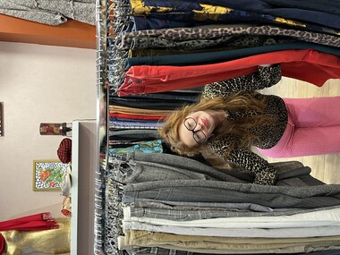 Une femme devant de nombreux pantalons